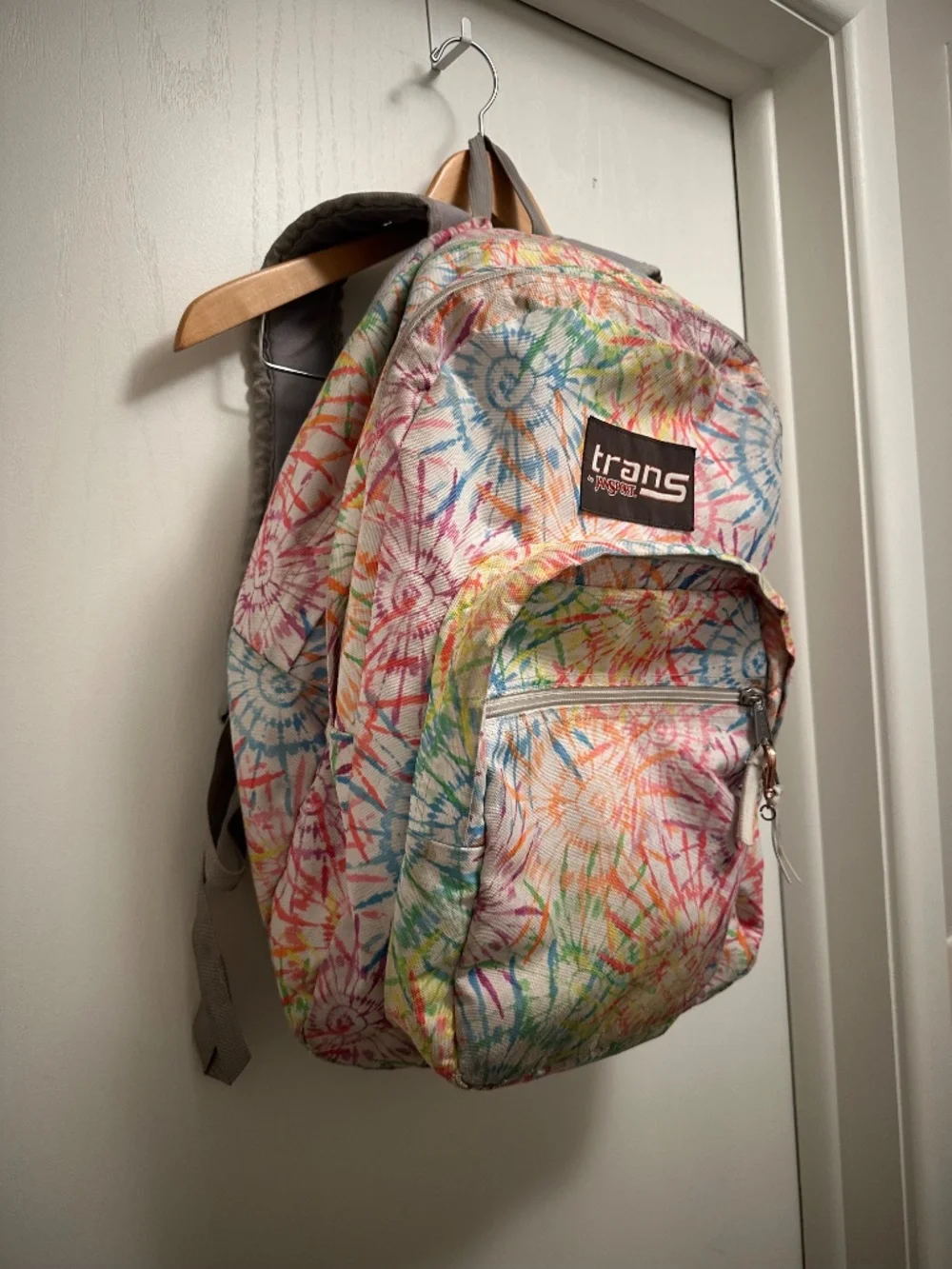 JanSport Trans backpack in a colorful multicolor floral/tie-dye style print